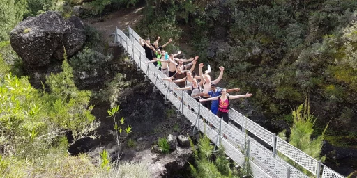 Junge Menschen stehen auf einer Hängebrücke in tropischer Landschaft, Copyright: BZB