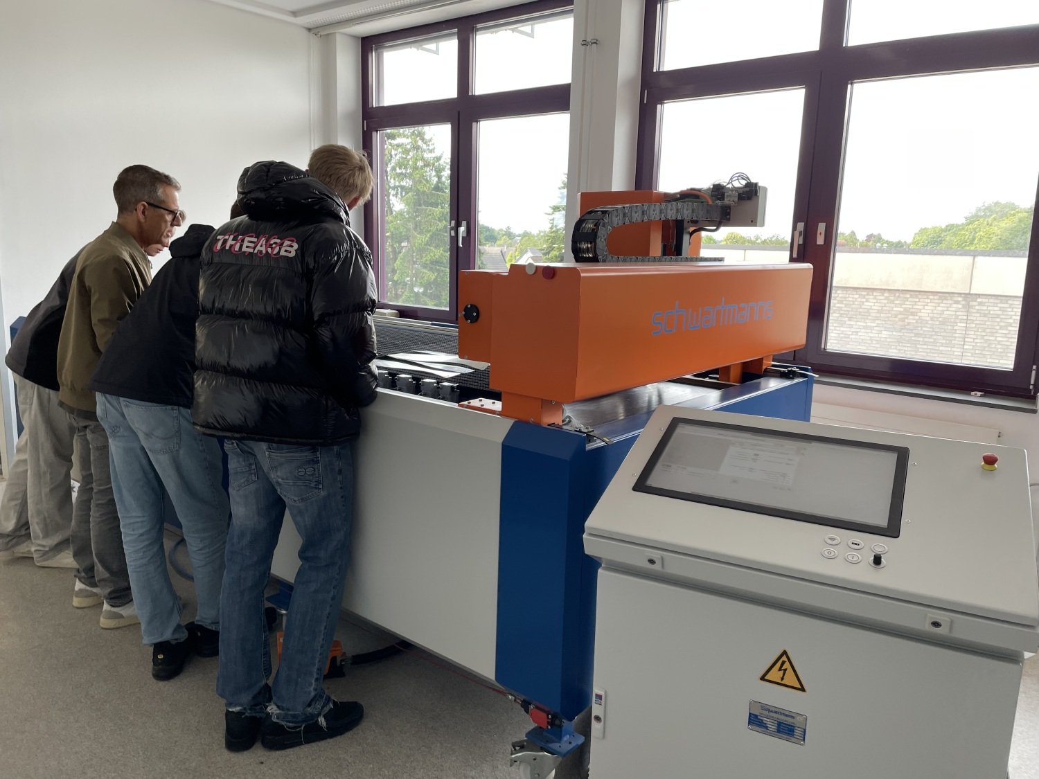 Besucher schauen sich die Zuschneidemaschine von Schwartmanns an., Copyright: BZB