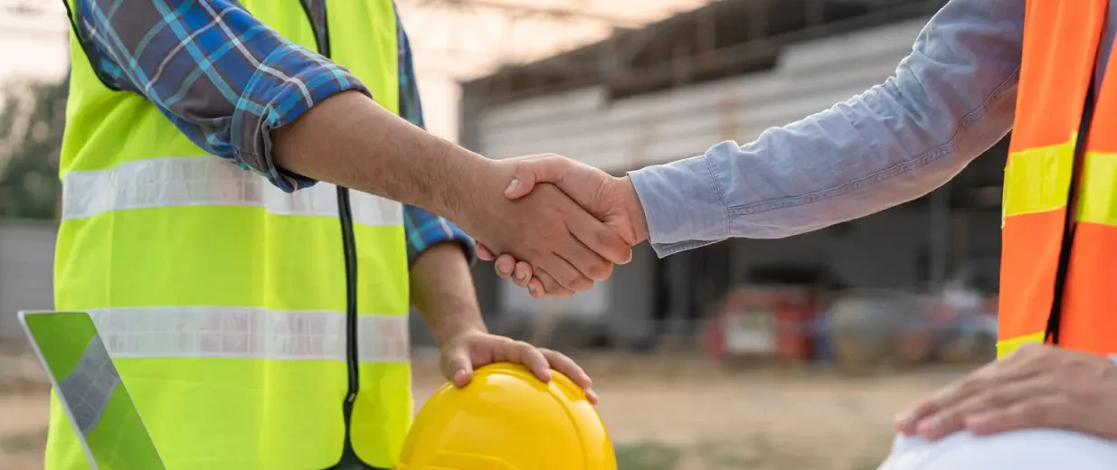 Bauarbeiter schütteln Hände - SOKA BAU feiert 50 Jahre geförderte Berufsbildung – BZB feiern mit, Copyright: KMPZZZ - stock.adobe.com
