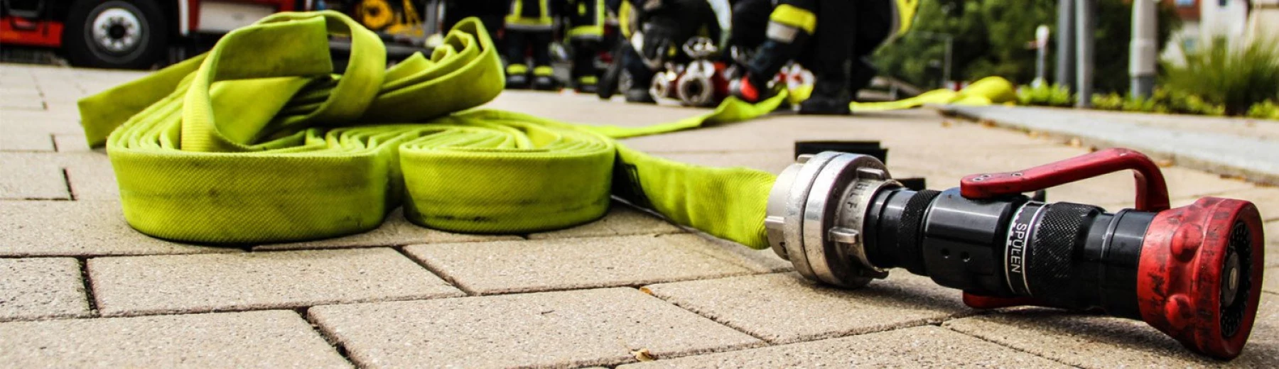Feuerwehrschlauch, der nach einem Einsatz aufgewickelt wird, Copyright: keine Angaben