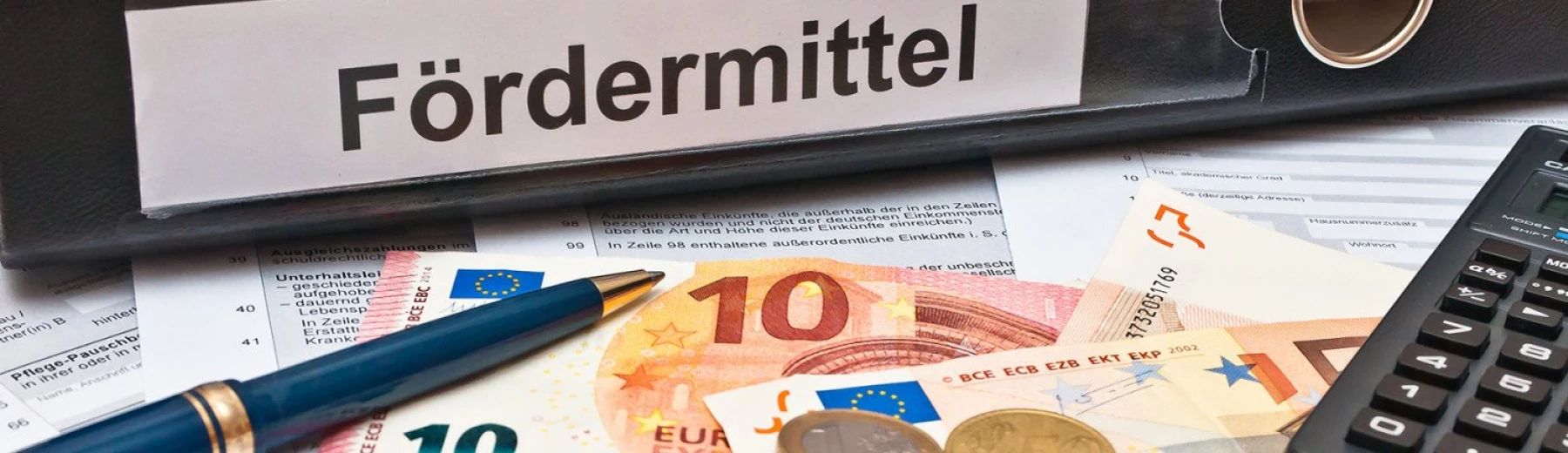 Ordner beschriftet mit Fördermittel und einige Geldscheine auf einem Tisch, Copyright: keine Angaben